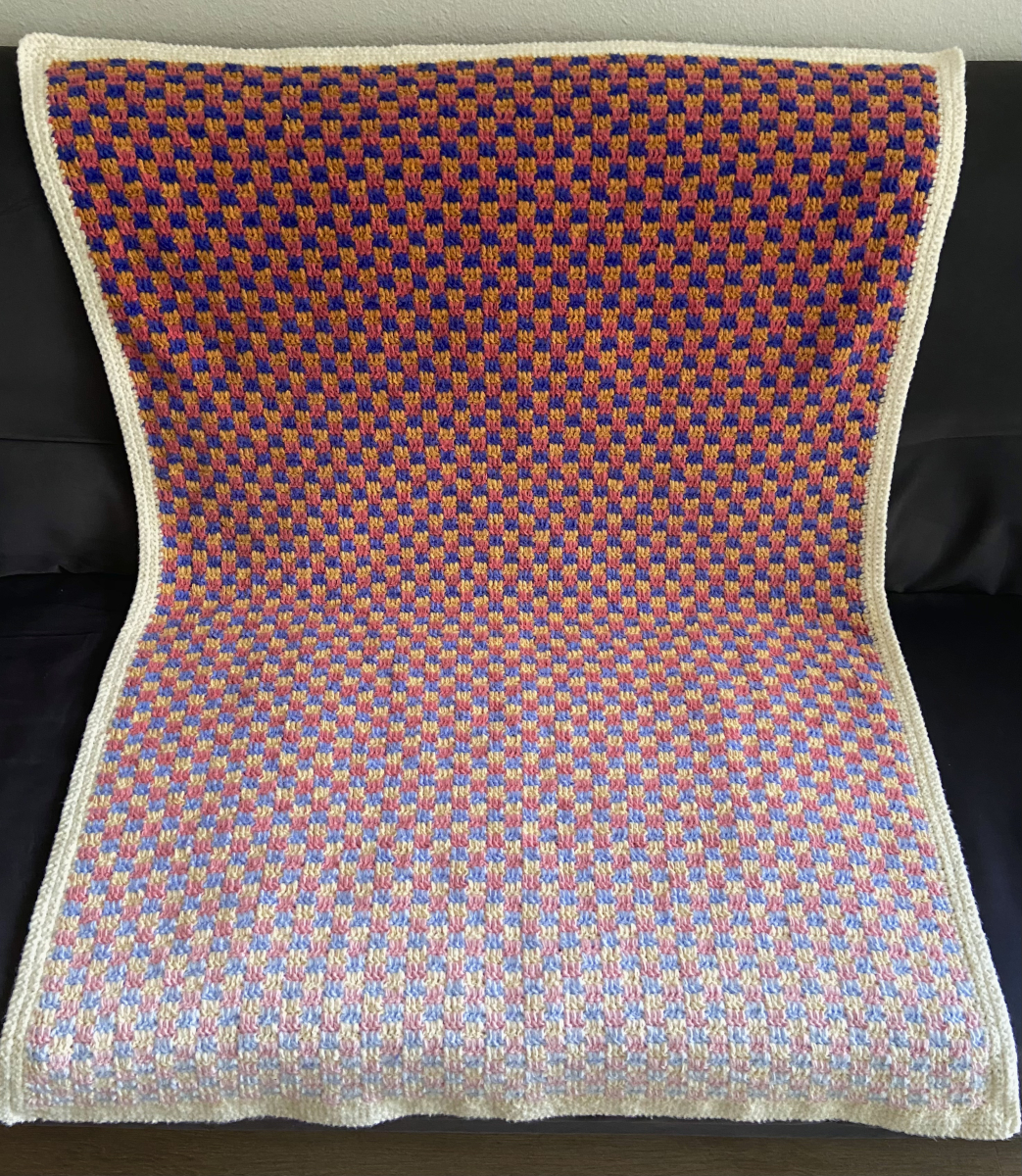 checkerboard crochet blanket in yellow, blue, red, and white